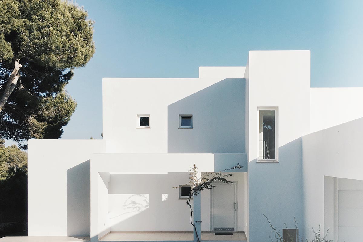 Modern white building under clear blue sky.