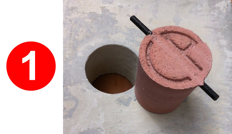 Red cylinder beside circular hole in concrete.