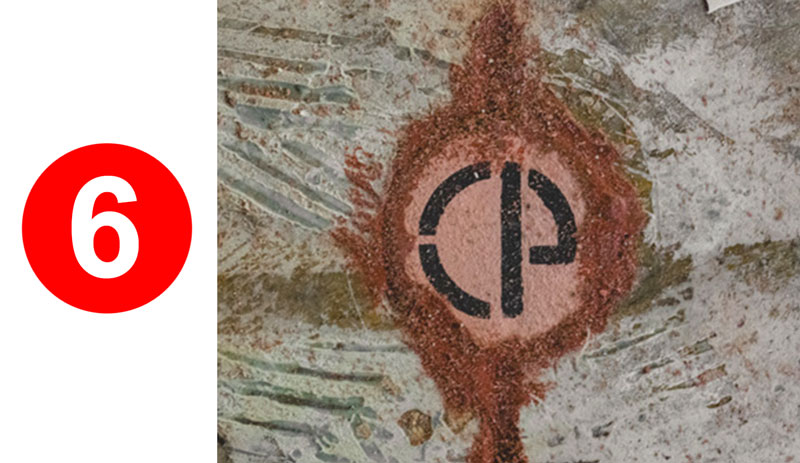 Red number six and circular black emblem.